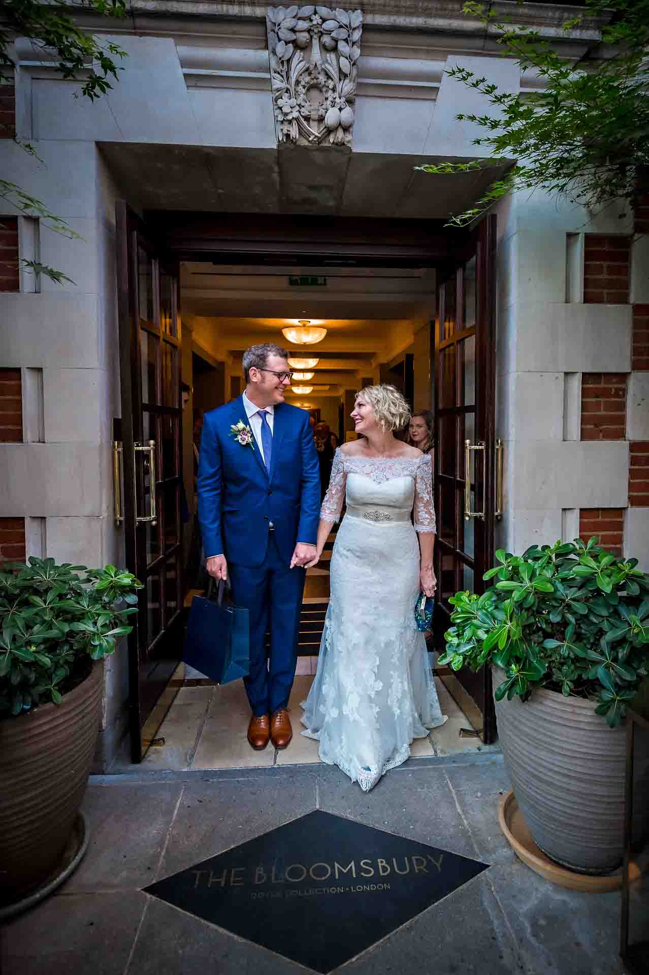 Wedding couple looking at each other at entrance door of Bloomsbury Hotel