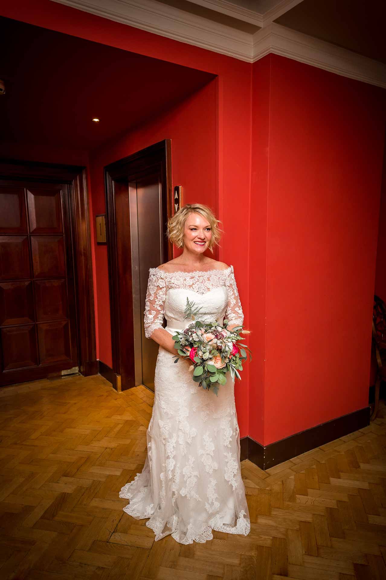 Bride standing in corridor holding her bouquet in the Bloomsbury Hotel