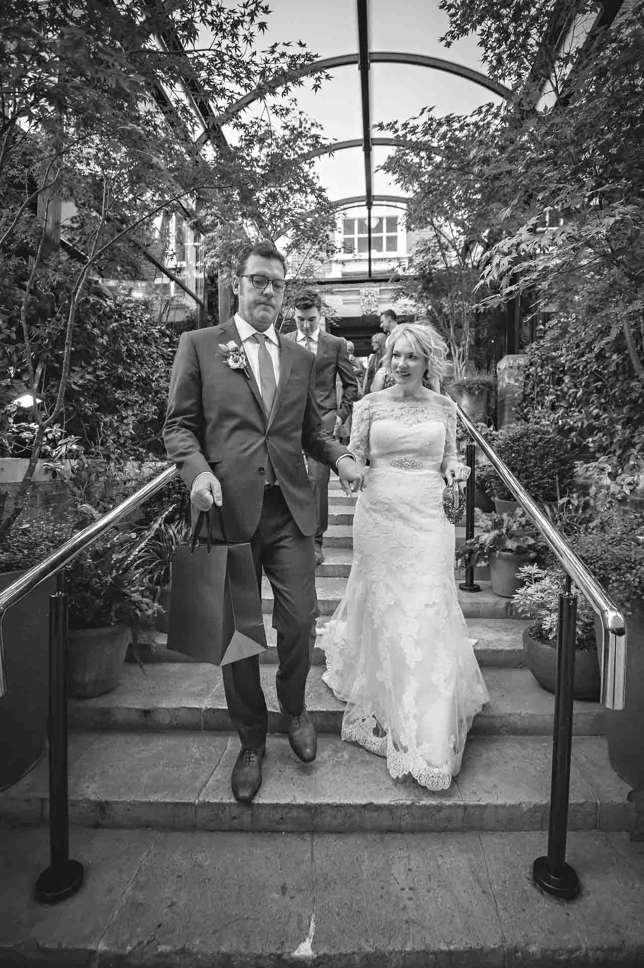 Portrait of bride and groom walking outside Bloomsbury Hotel