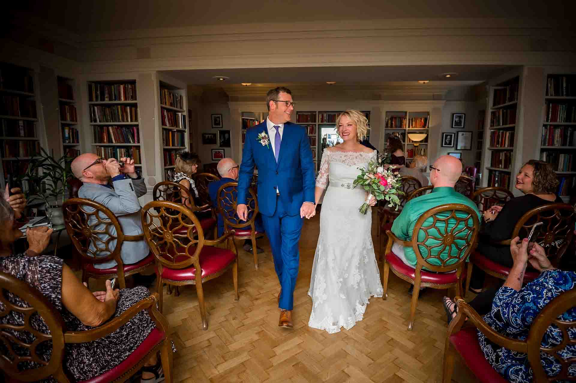 Bride and Groom walking up the aisle in library at the Bloomsbury Hotel