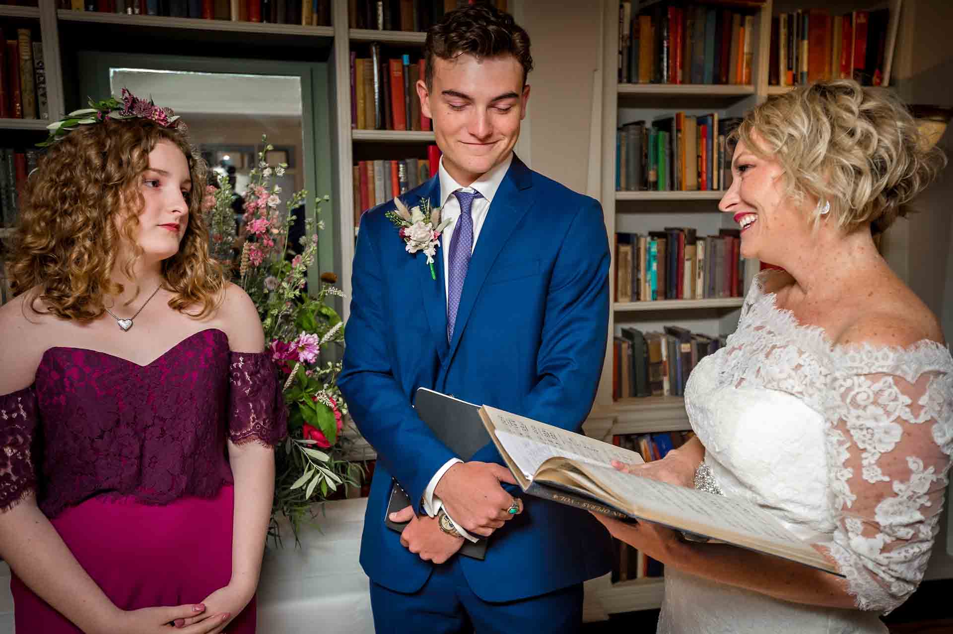 Bride reading whilst son and daughter watch on at wedding in London