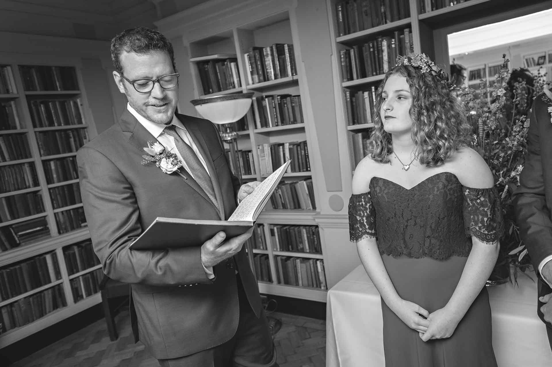 Groom Reading with Bridesmaid Listening at London Marriage Ceremony