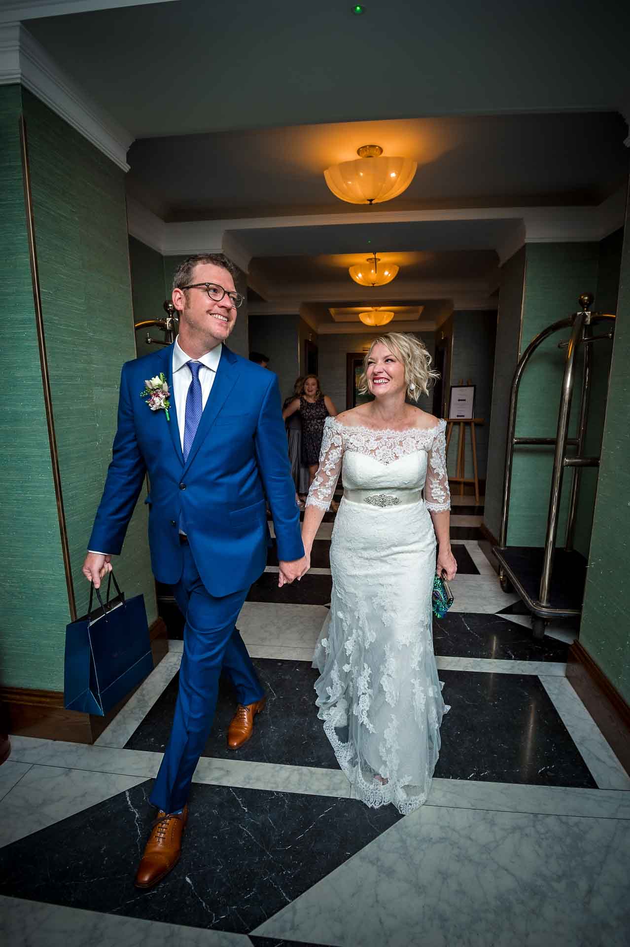 Bride and groom smiling as they walk along in hotel reception