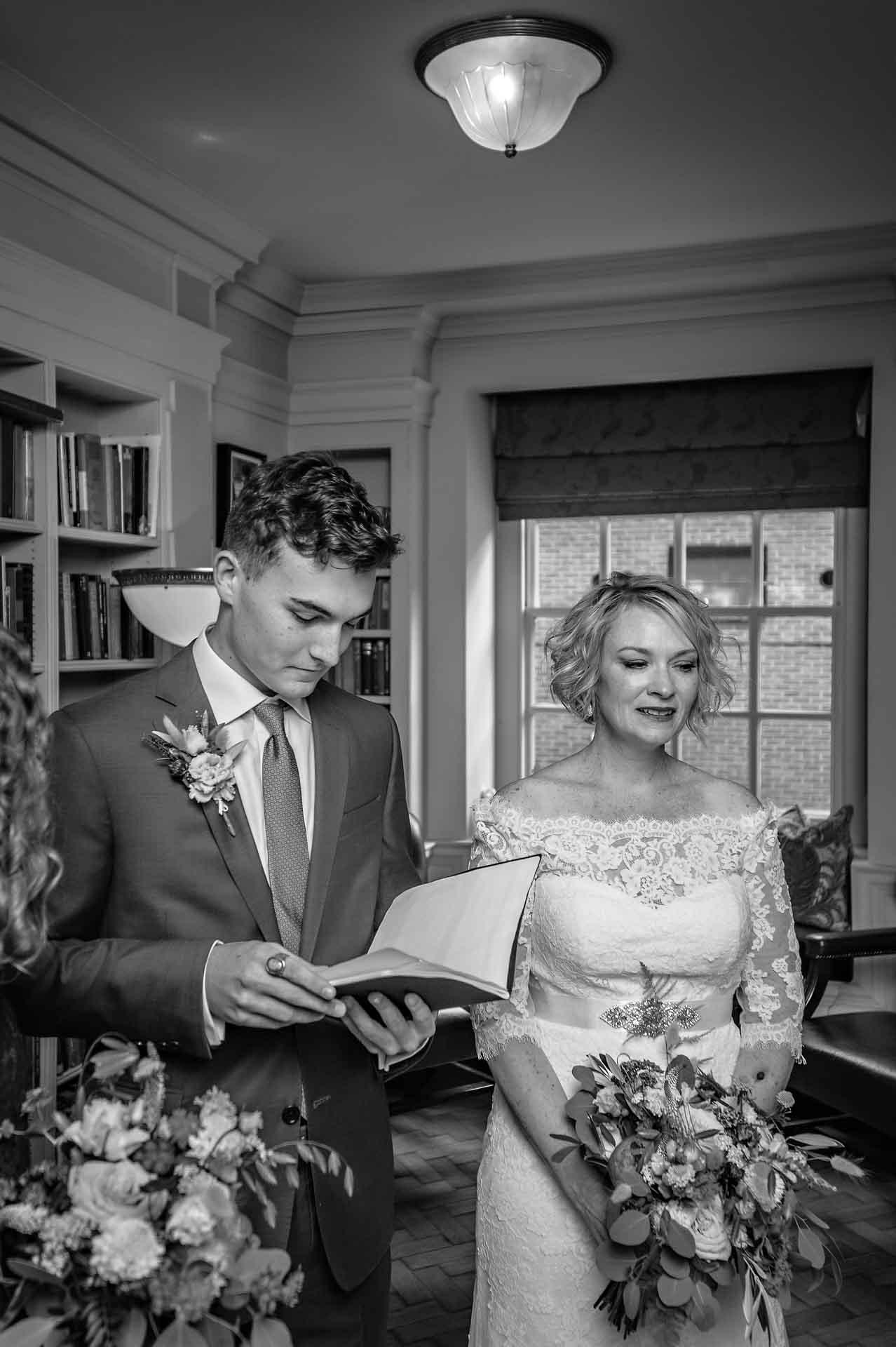 Bride's son reading as she listens at wedding ceremony