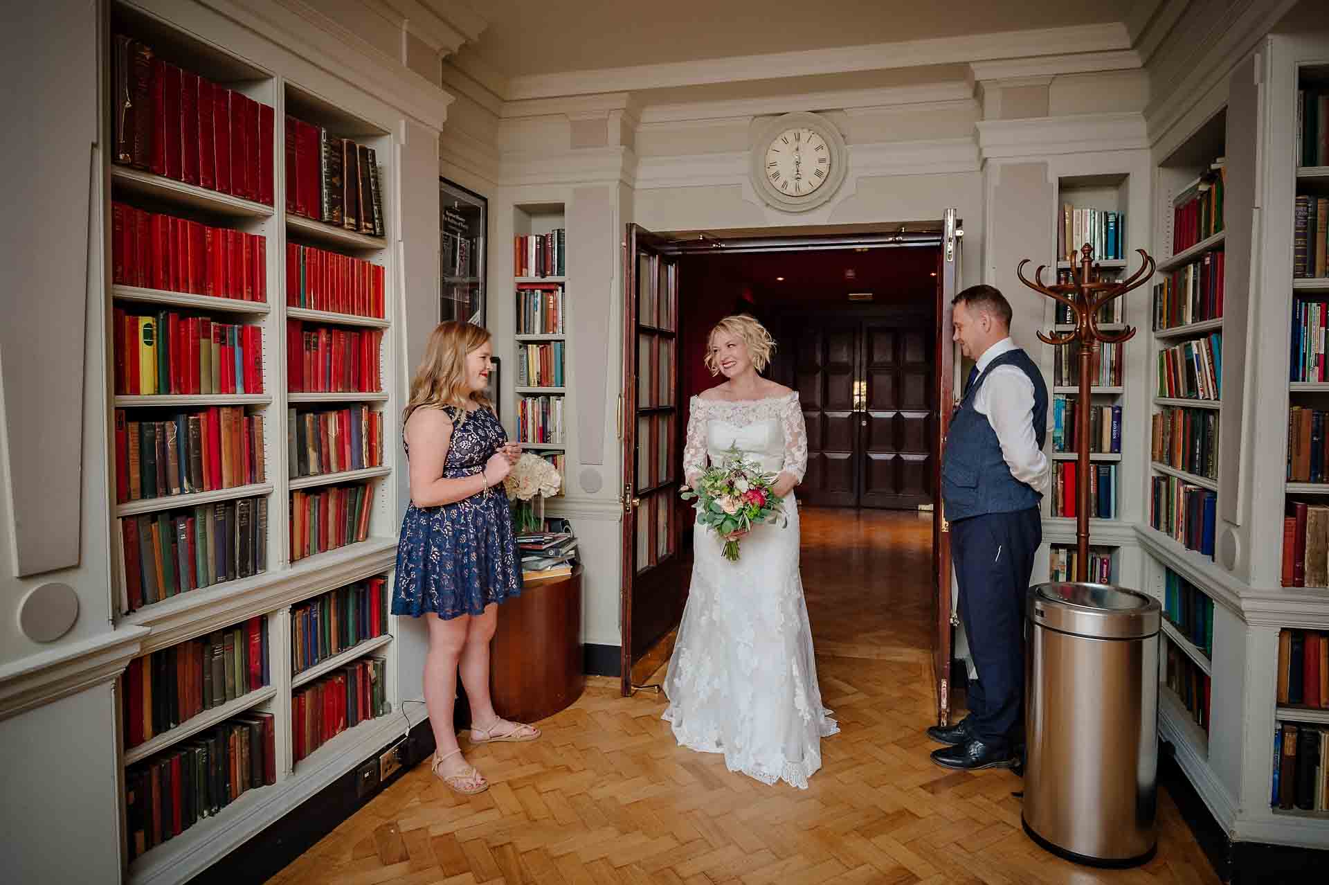 Bride entering Seamus Heaney Library at Bloomsbury Hotel with guest and staff watching