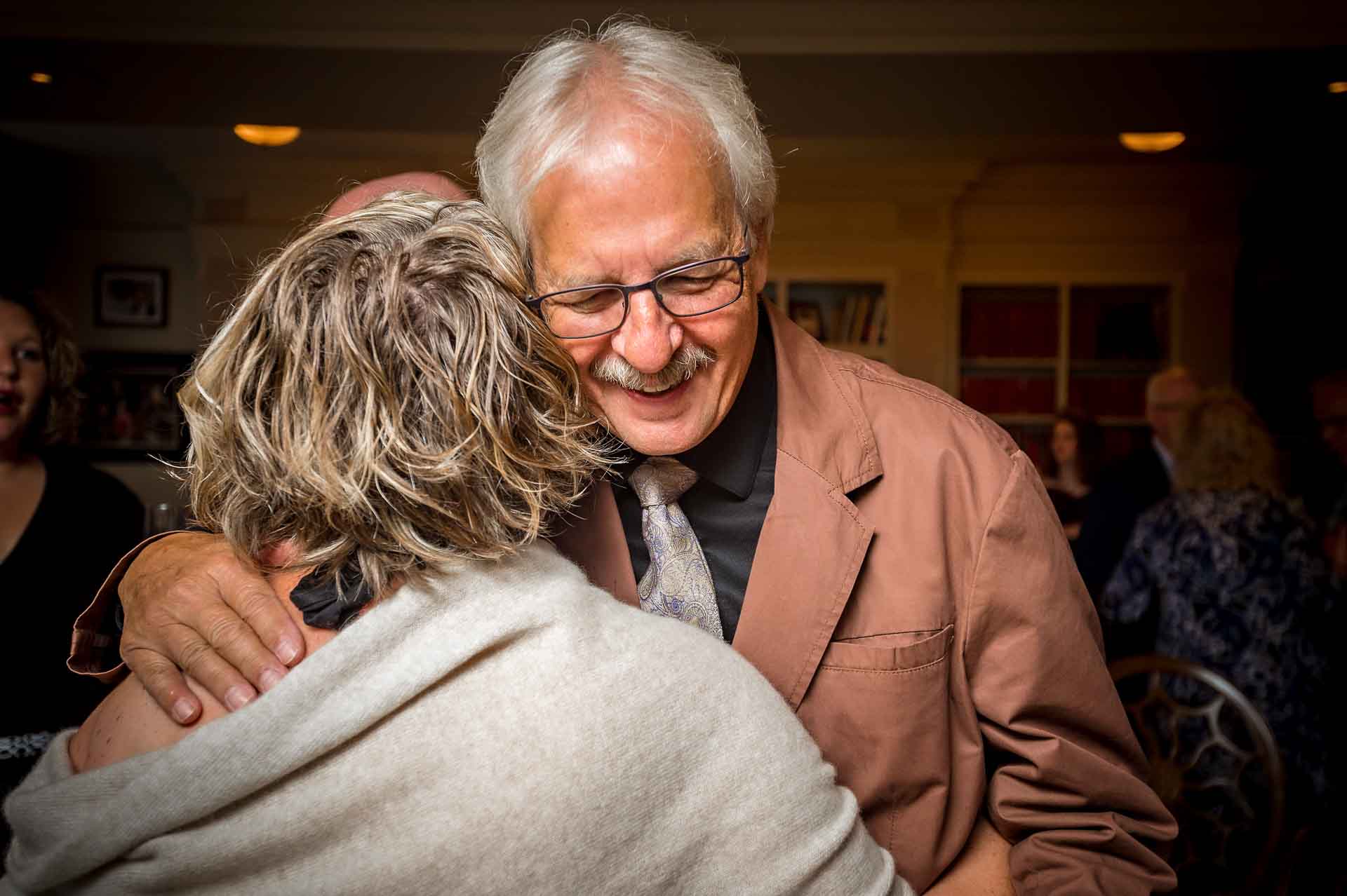 Male and female guests hugging before wedding