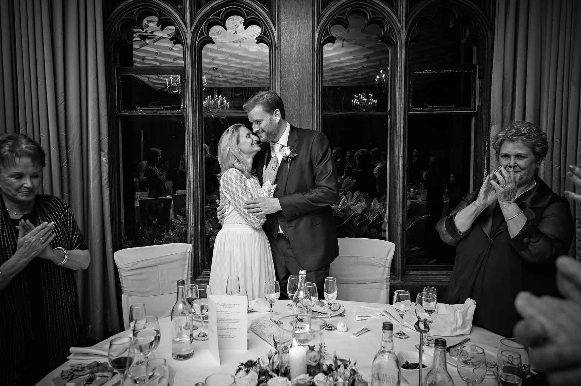 Bride and groom holding each other at wedding speeches