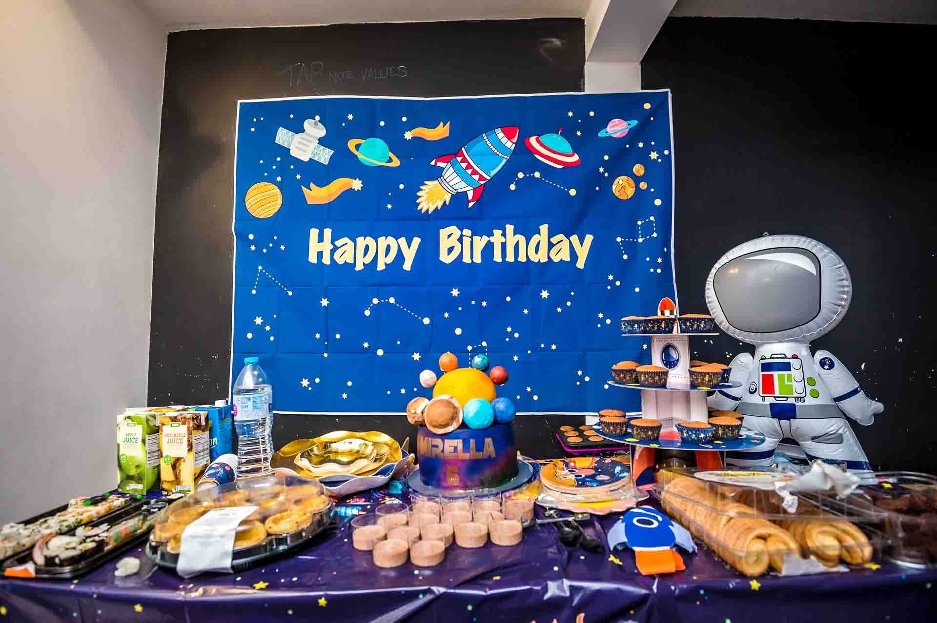 Table of food and cake with 'Happy Birthday' sign laid out for child's party