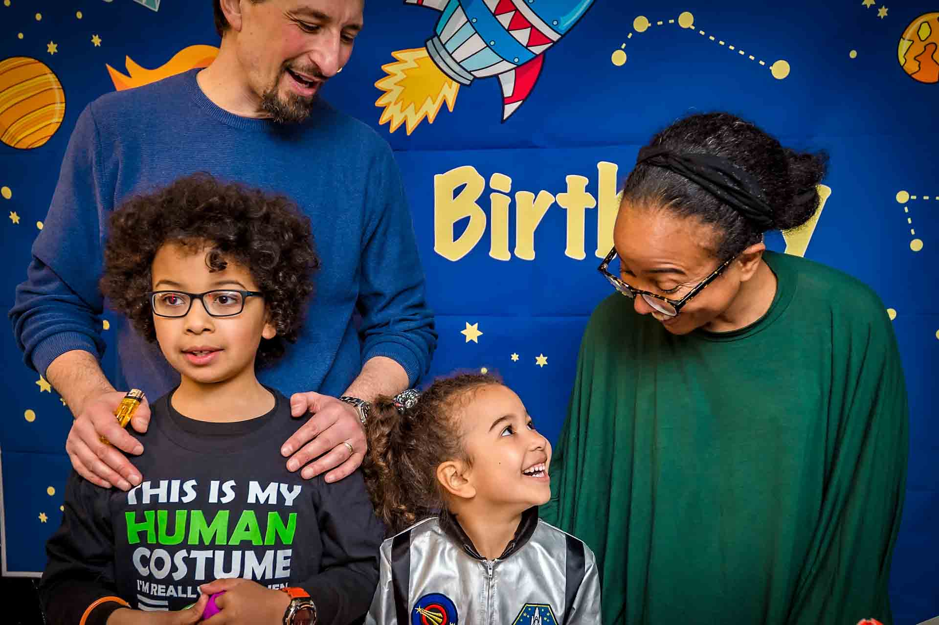Black and white couple kissing Little girl laughing with family at birthday party