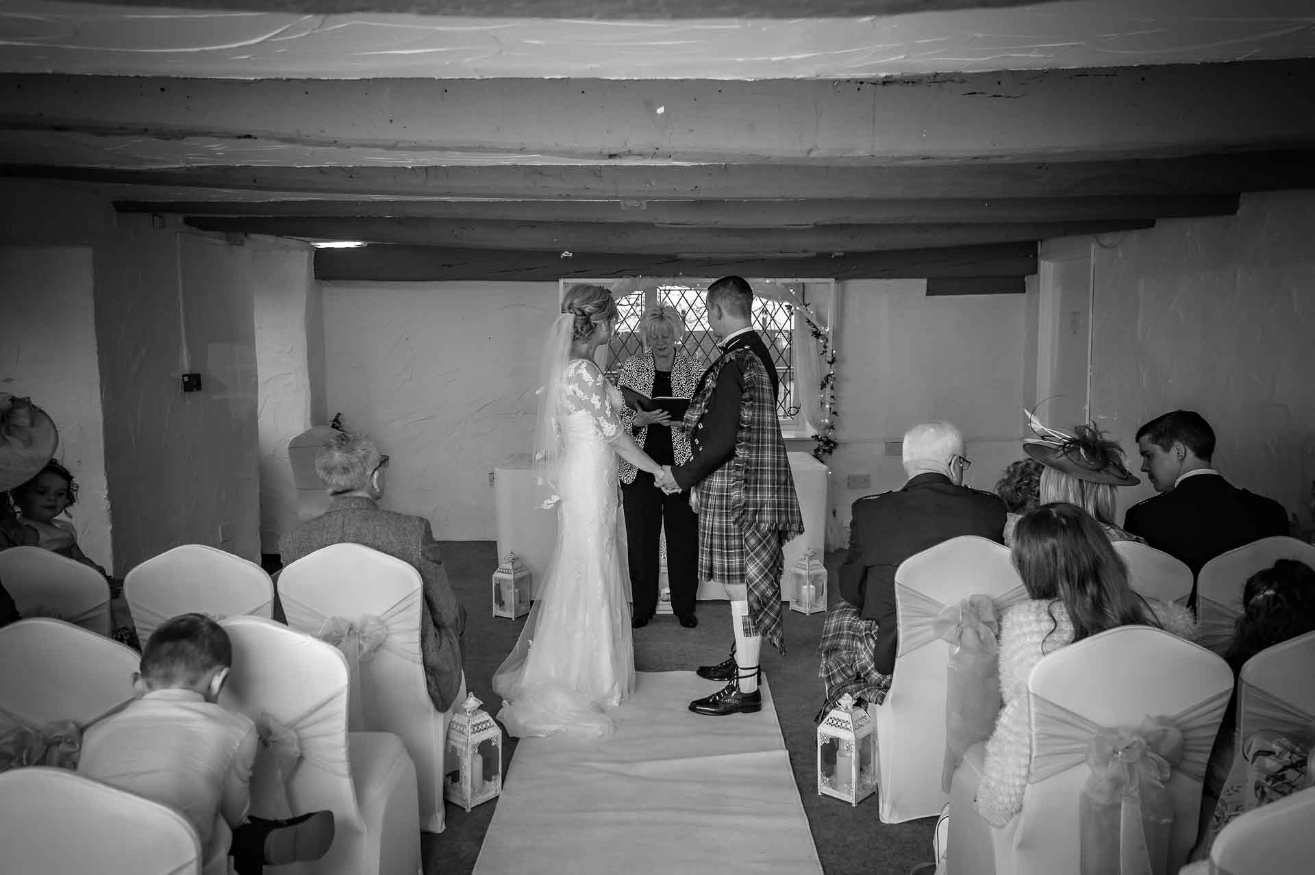 The couple hold hands at marriage ceremony in the Nelson Suite of Llechwen Hall Hotel