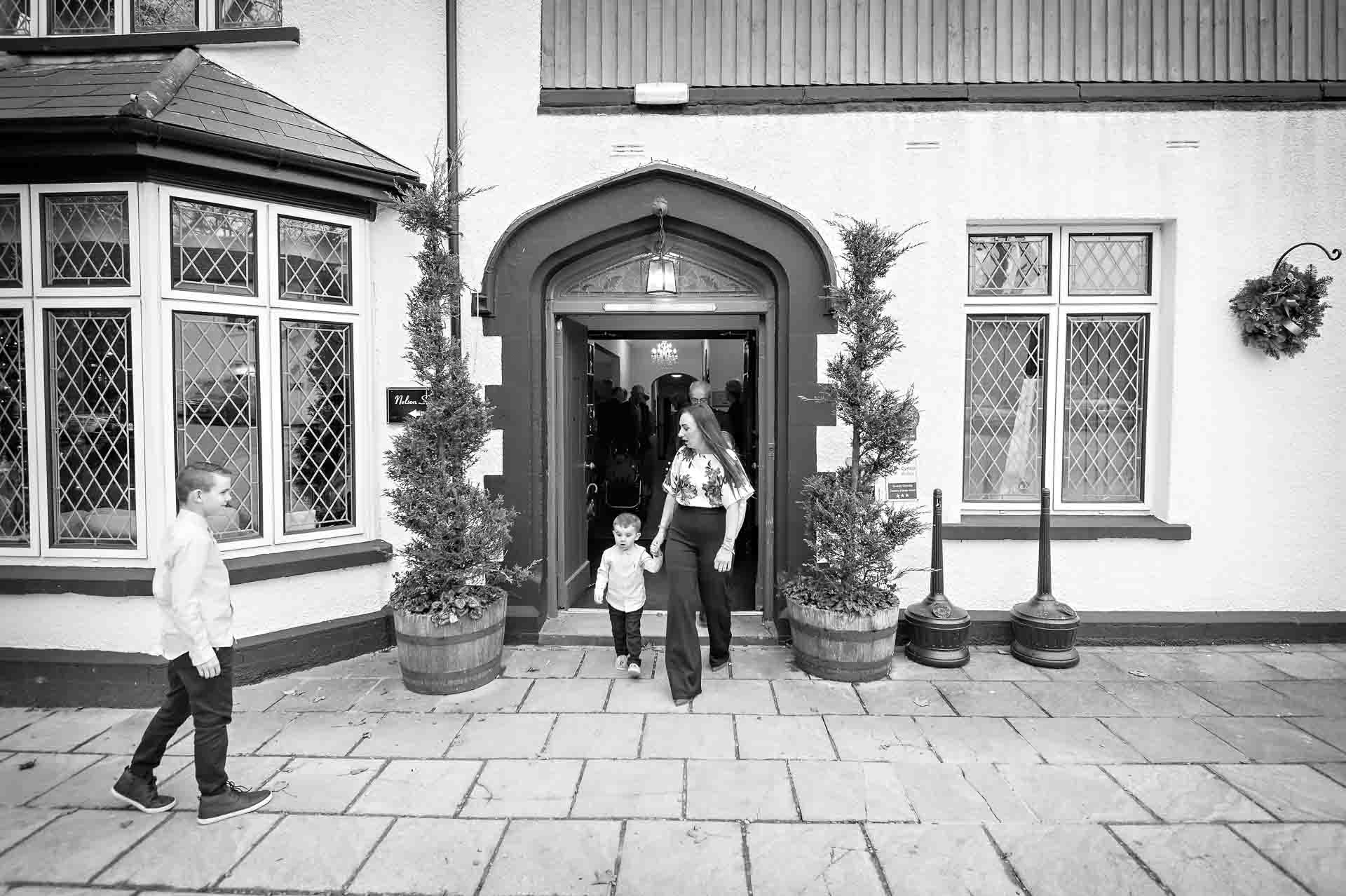Front of Llechwen Hall Hotel with guests walking out of door