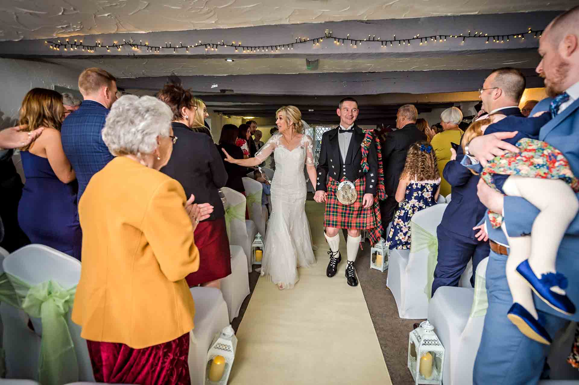 The bride and groom walking back down the aisle after wedding ceremony at Llechwen Hall Hotel