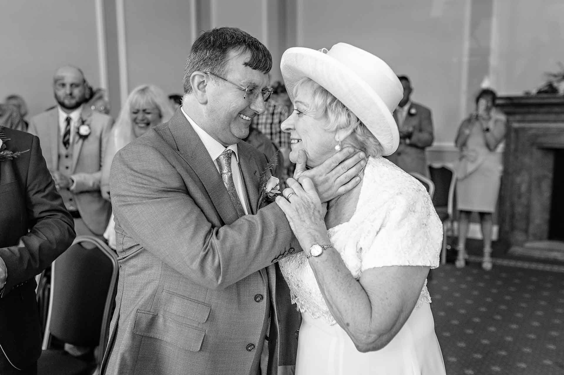 Older Wedding Couple Holding Each Other After Ceremony