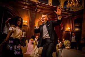 Groom dancing with guests at wedding at Porchester Hall, London