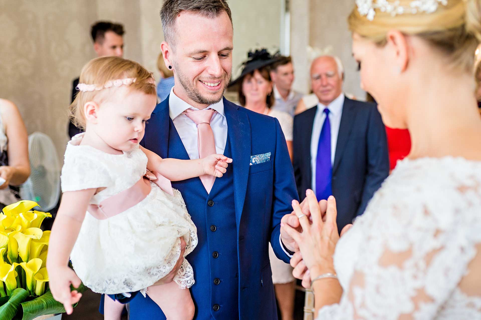 Short Notice Wedding in South London - Groom with Baby Placing Ring on Bride's Finger
