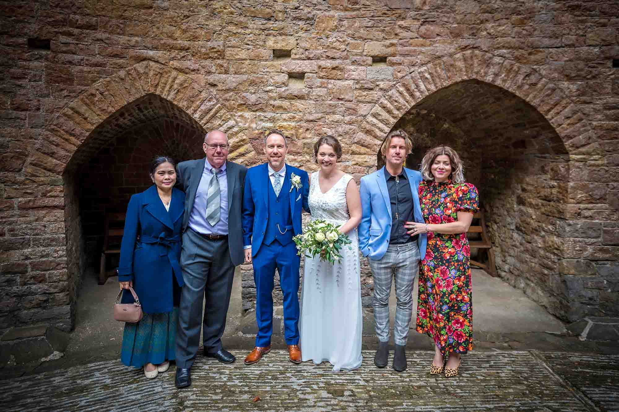 Posed family wedding portrait taken in Castell Coch courtyard