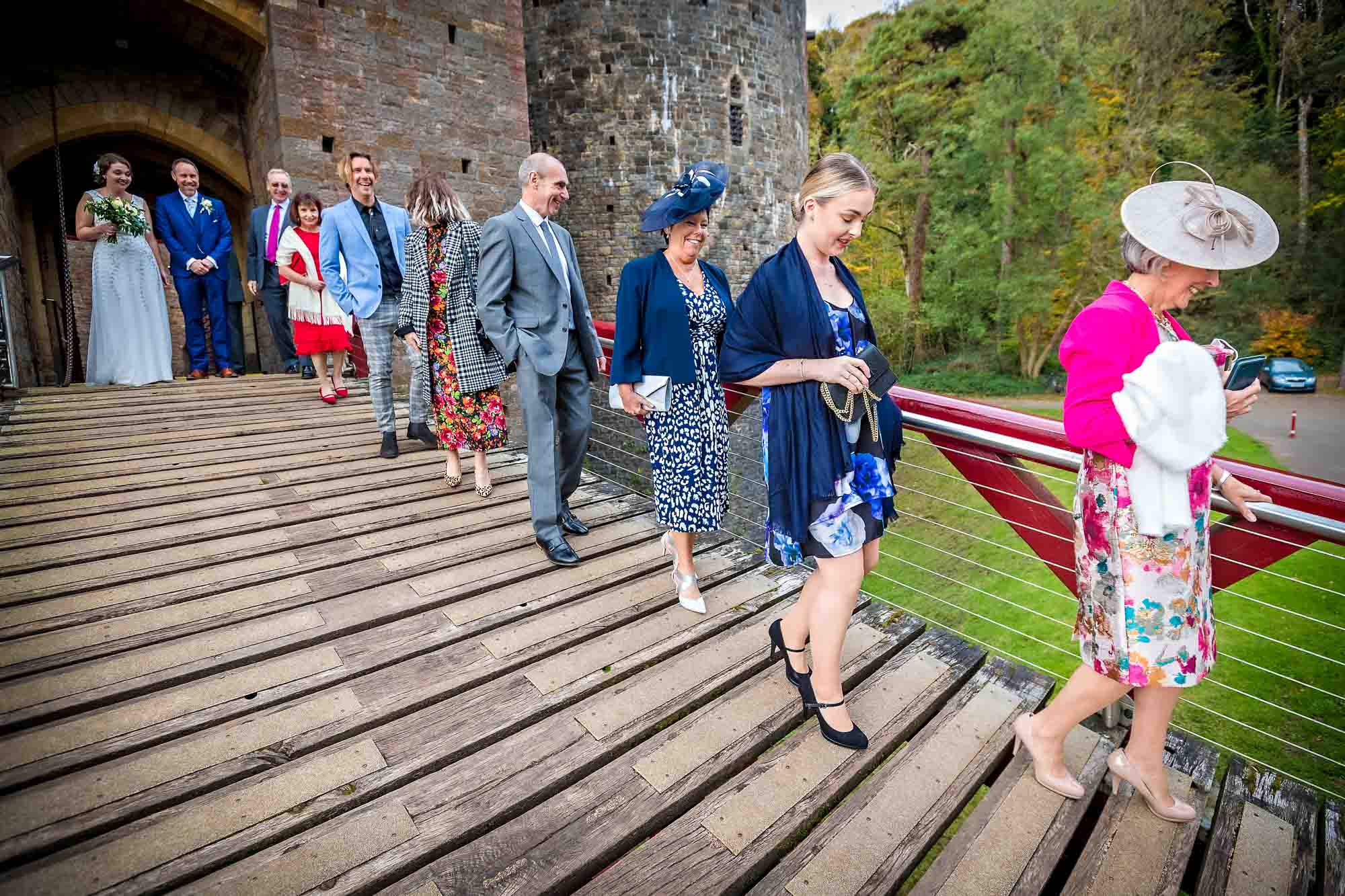 Wedding guests leaving Castell Coch, being very careful not to trap their heels in the drawbridge gaps