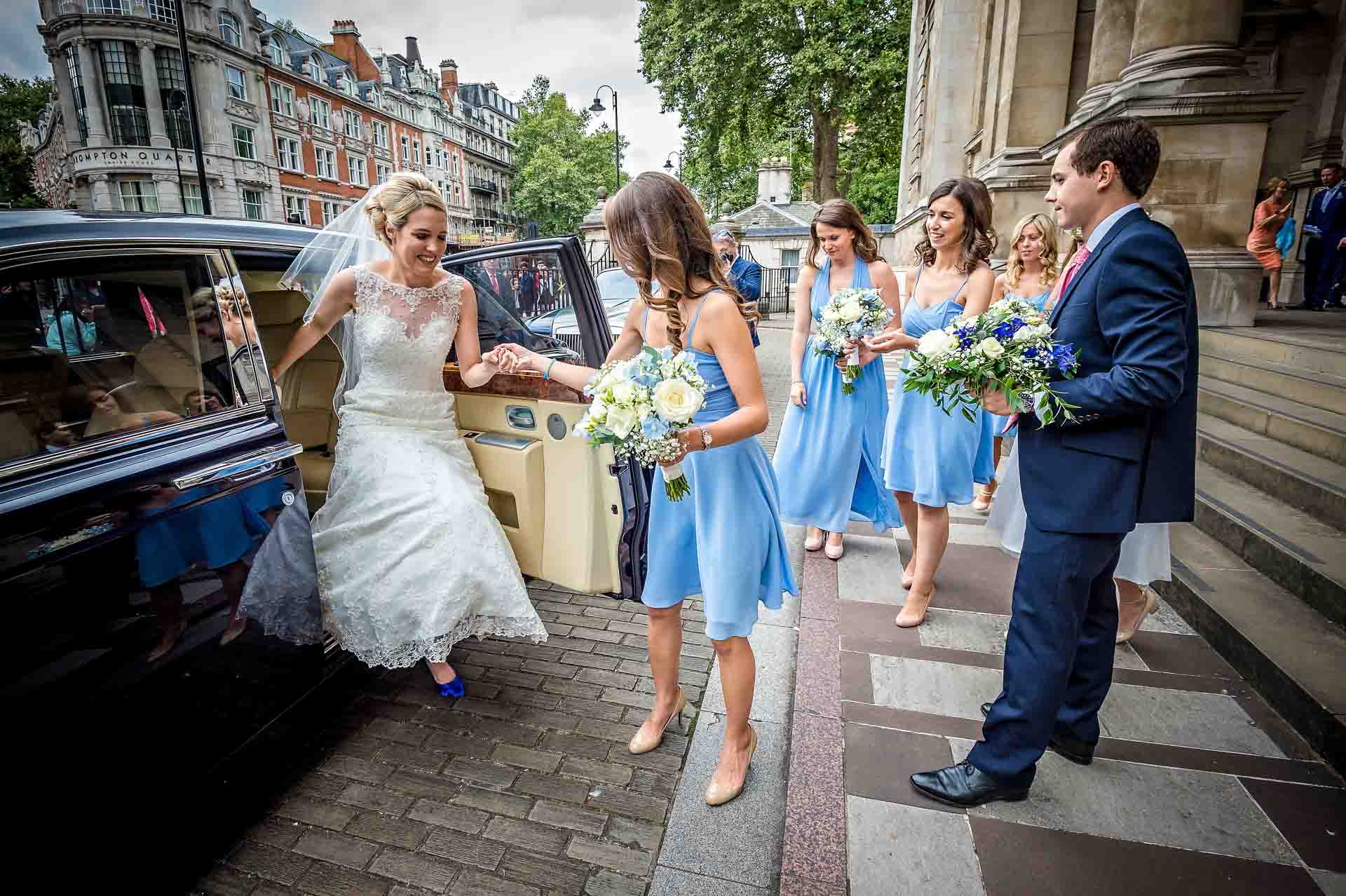 Bride being helped from car at Brompton Oratory wedding