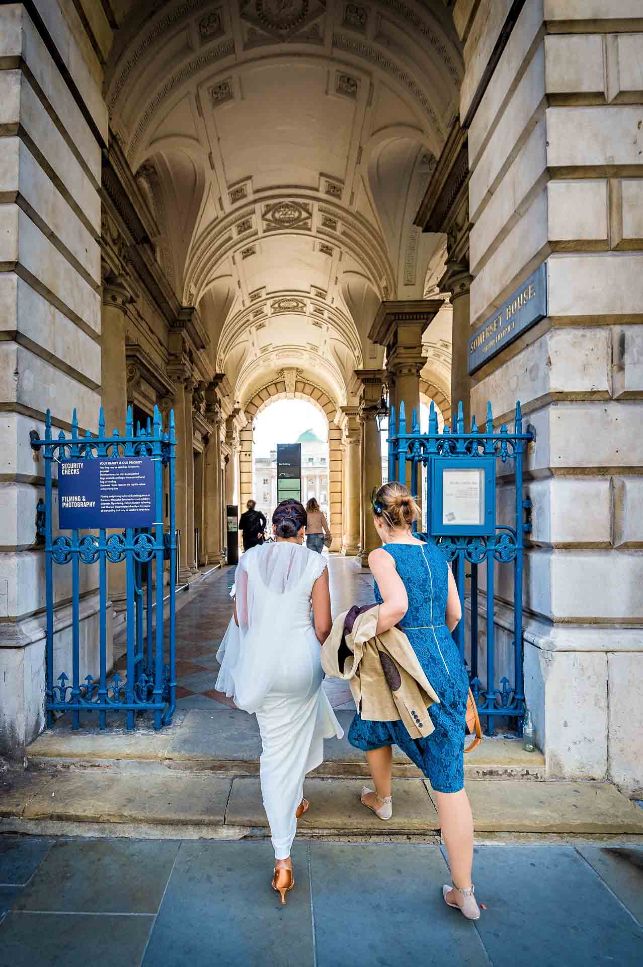 Back of bride and bridesmaid entering Somerset house for wedding