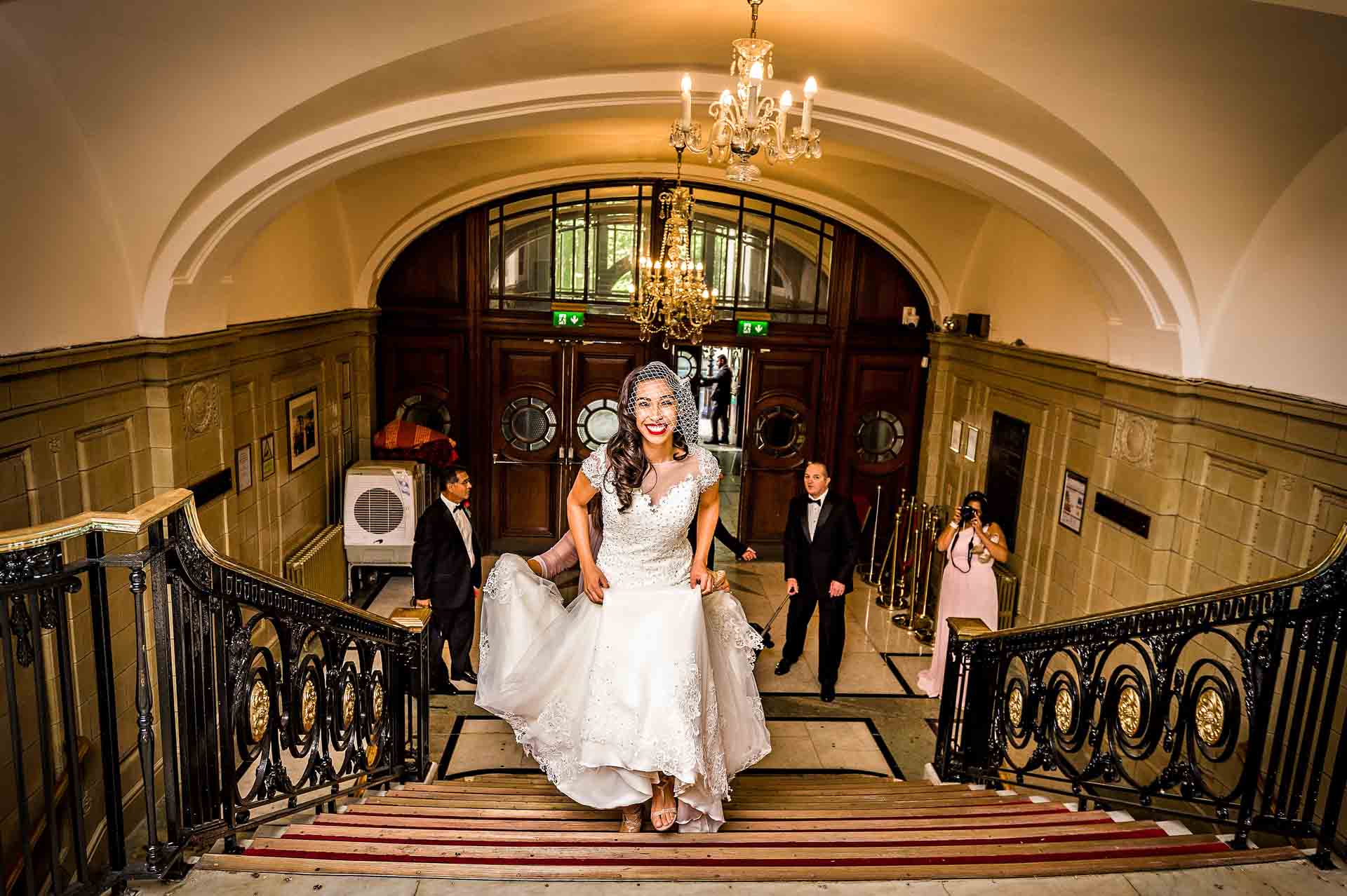 Bride walking up staircase at Porchester Hall