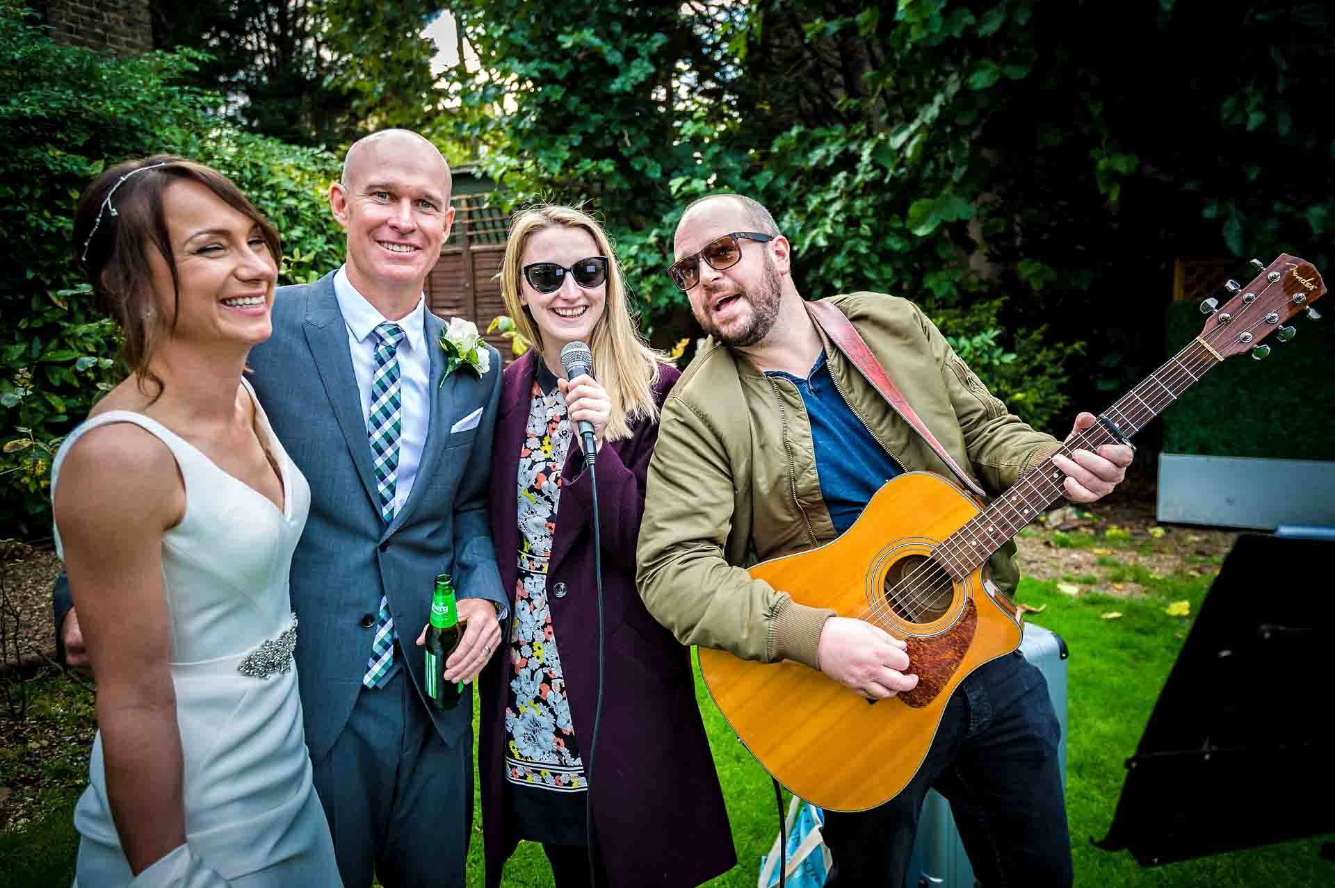 Wedding guitar dup serenading happy couple in garden