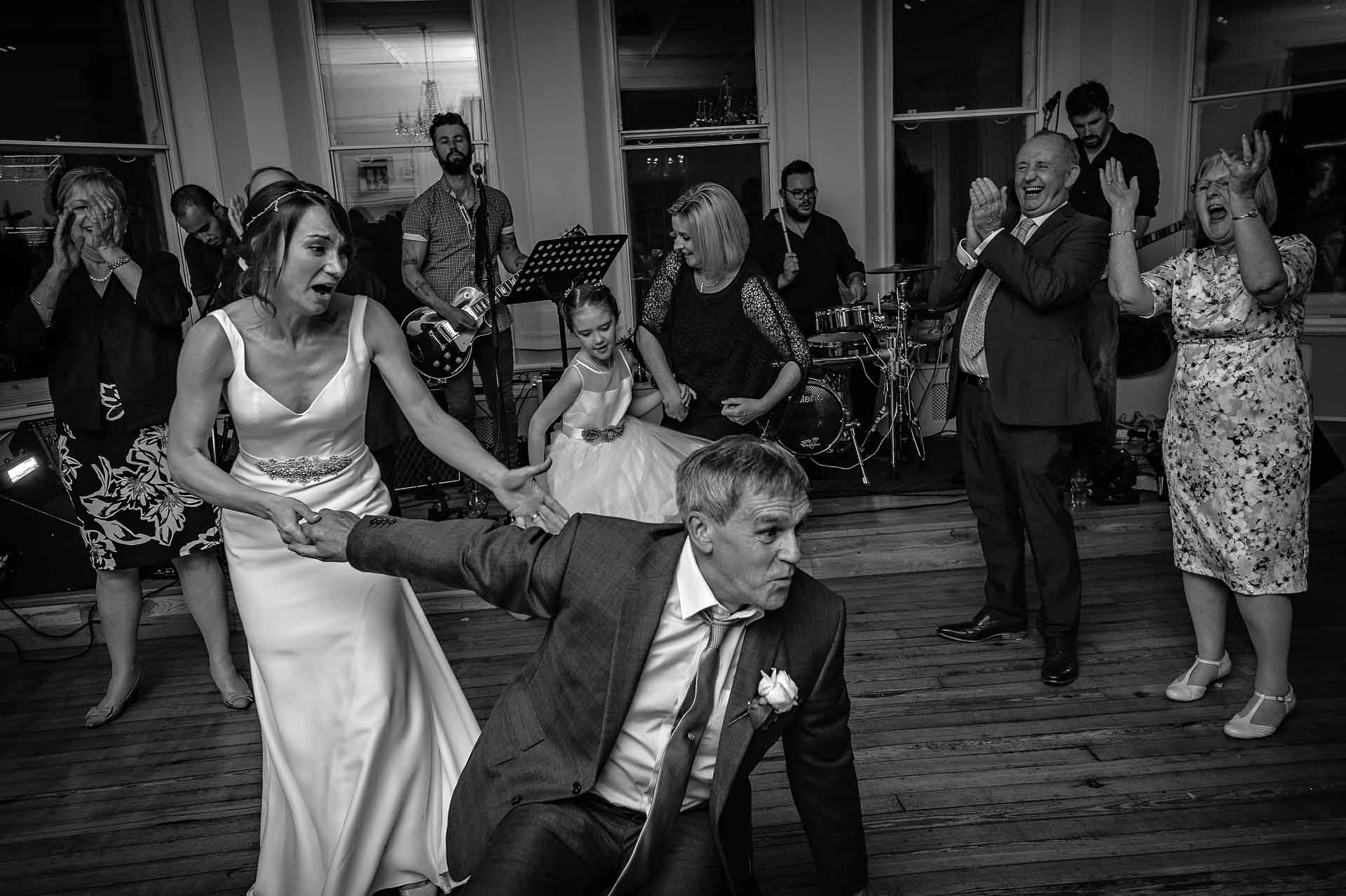 Man fallen on floor at wedding is helped up by bride
