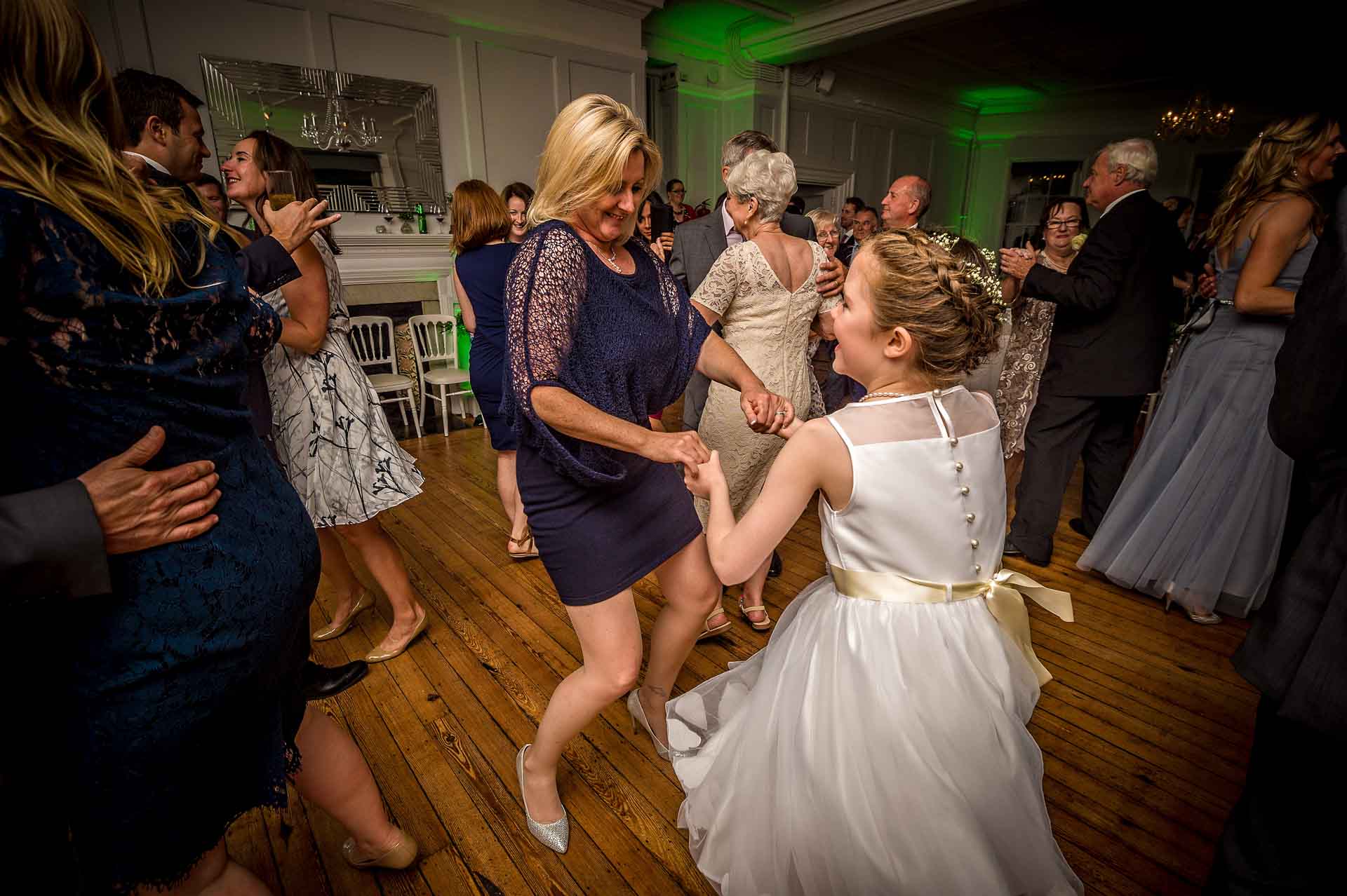 Woman dancing with girl at wedding