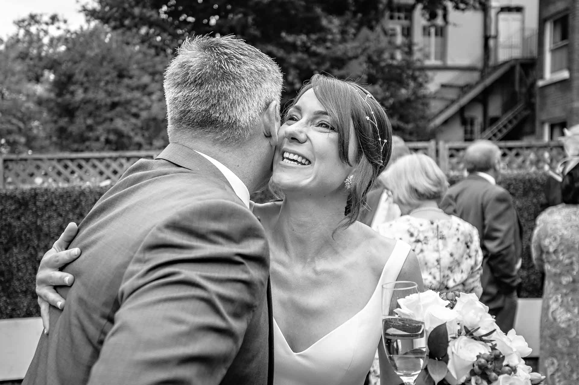 Bride hugging male wedding guest