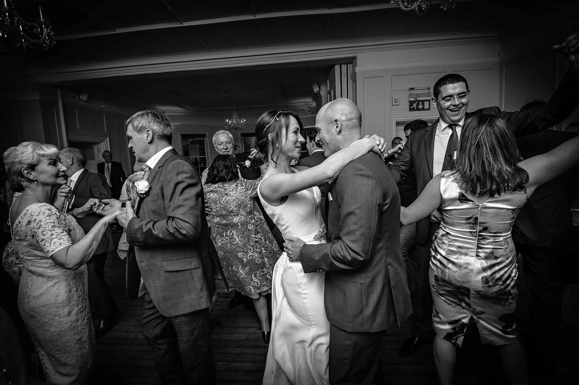 Couple and guests dancing at wedding in black and white