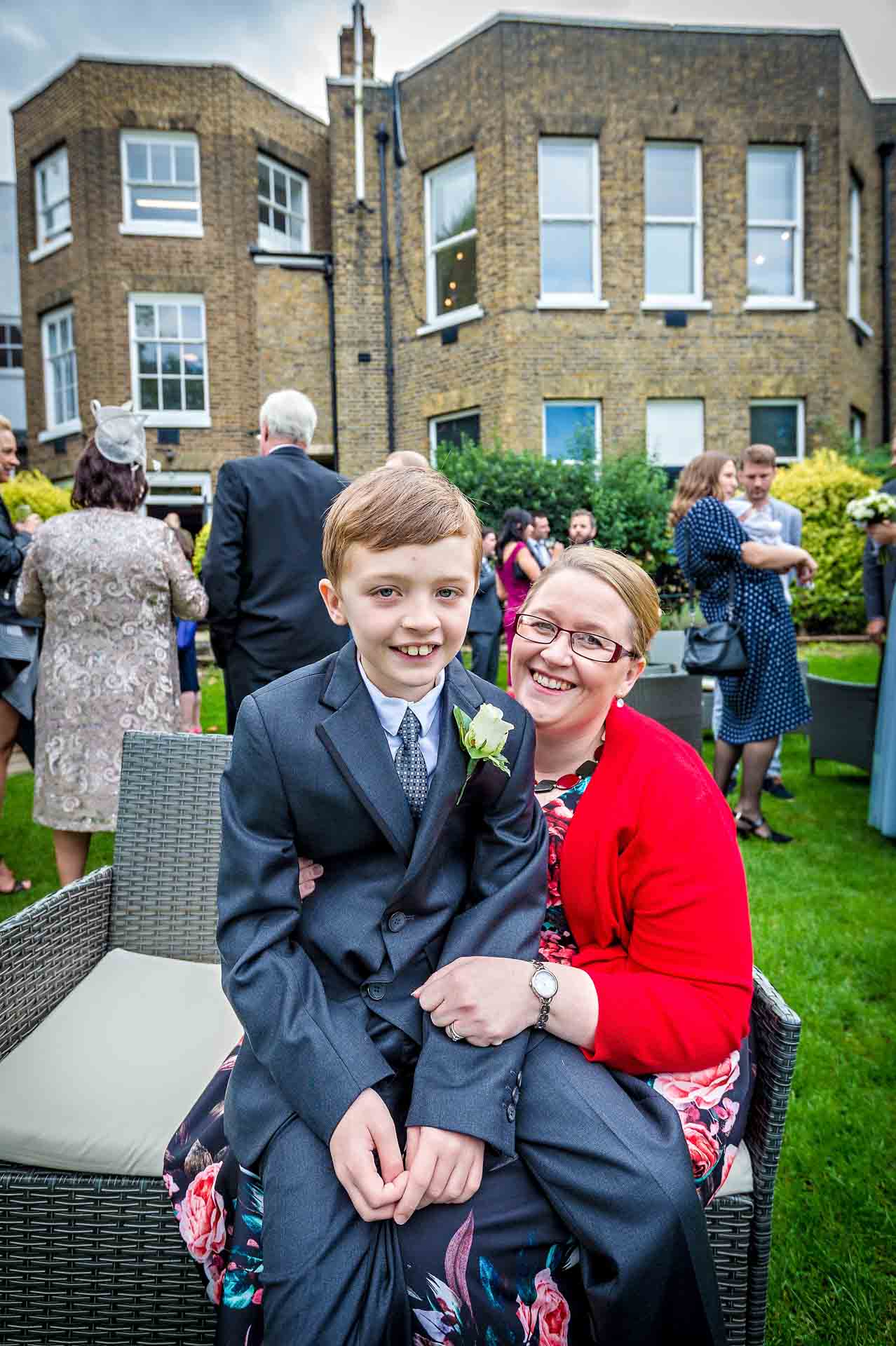 Boy sitting on mum's lap in garden of Winchester House