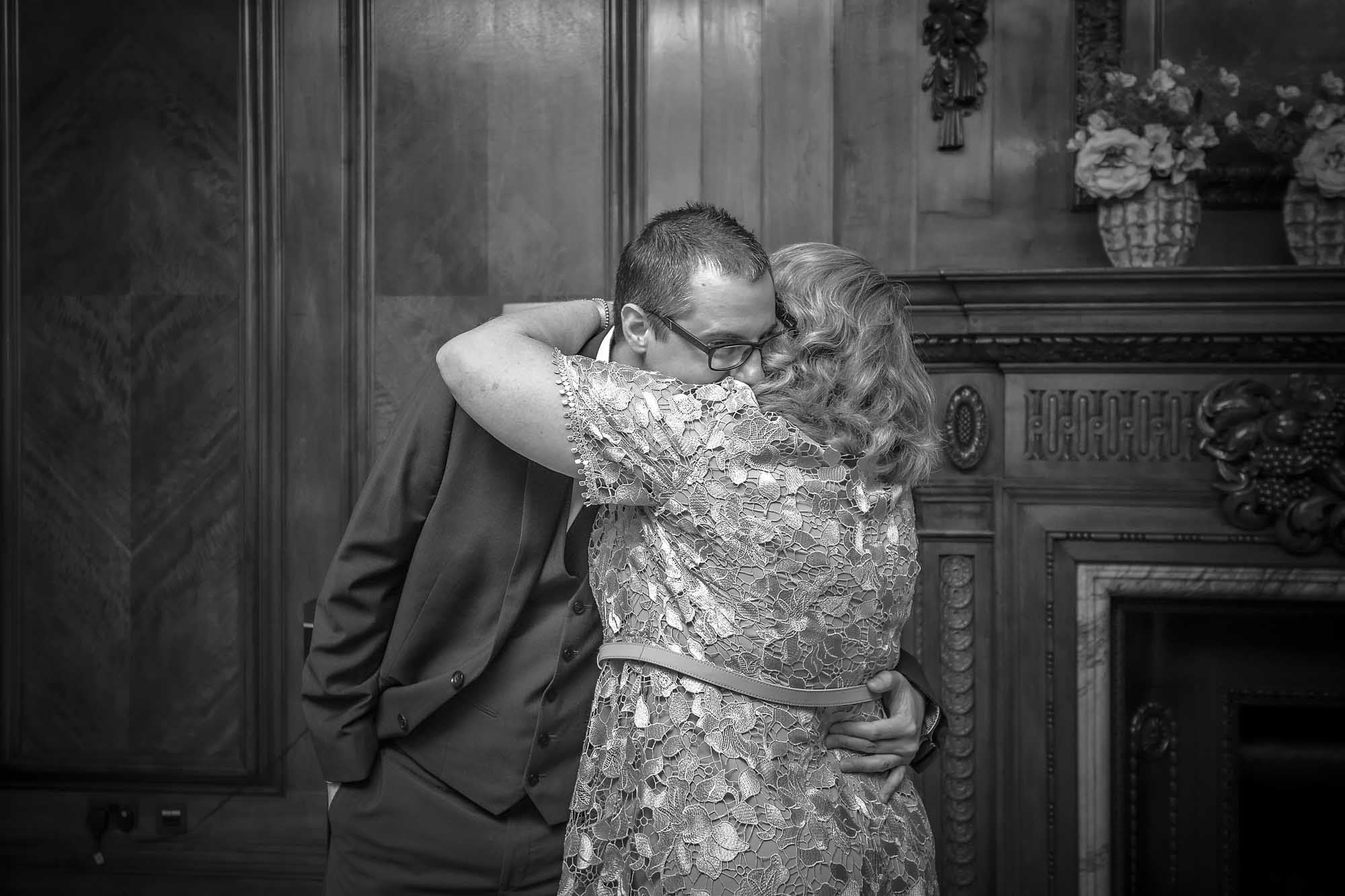 The groom's mother gives him a last minute hug before his wedding ceremony