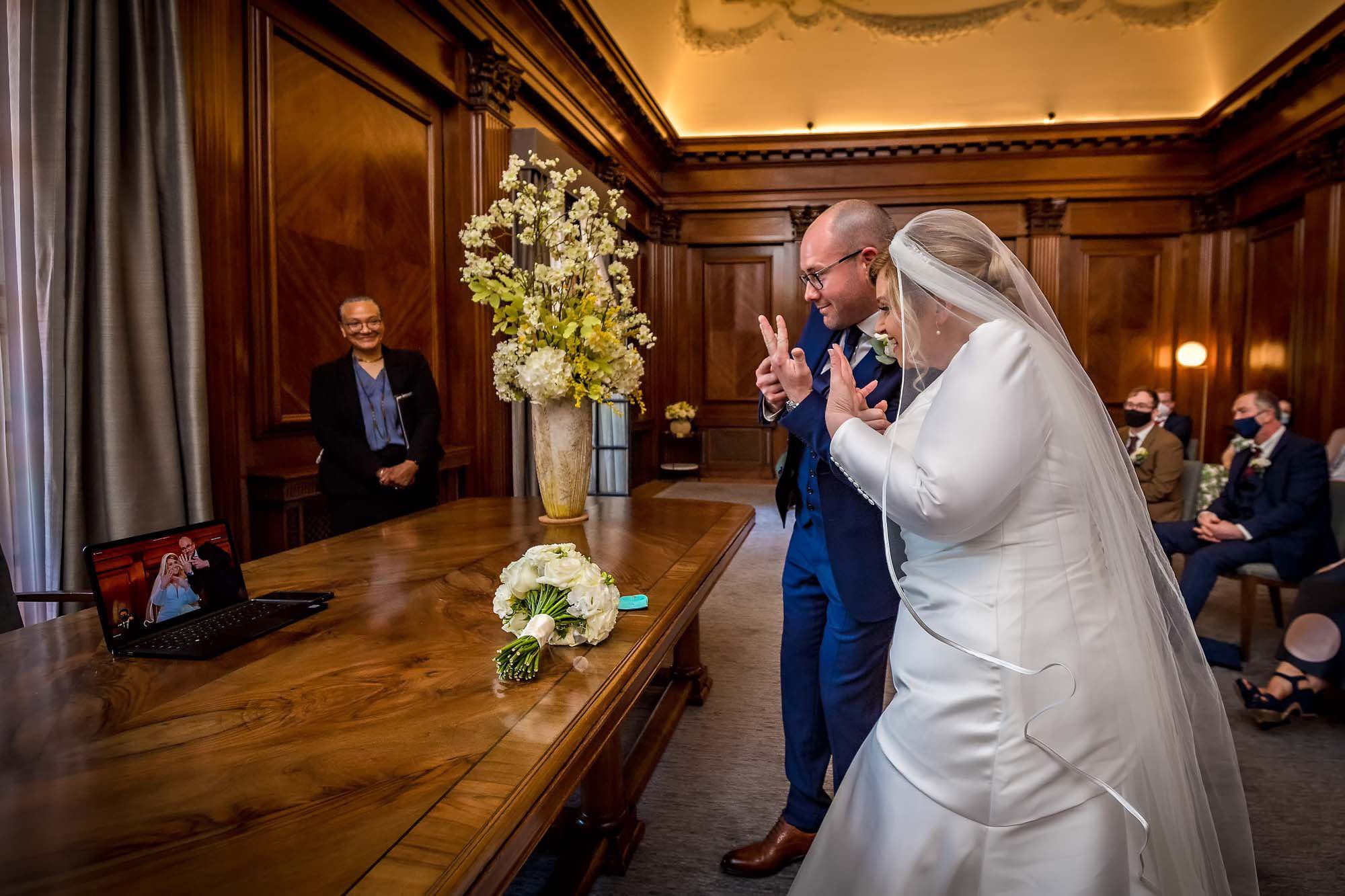 The happy couple show their wedding rings via a Zoom call in the Westminster Room at Old Marylebone Town Hall