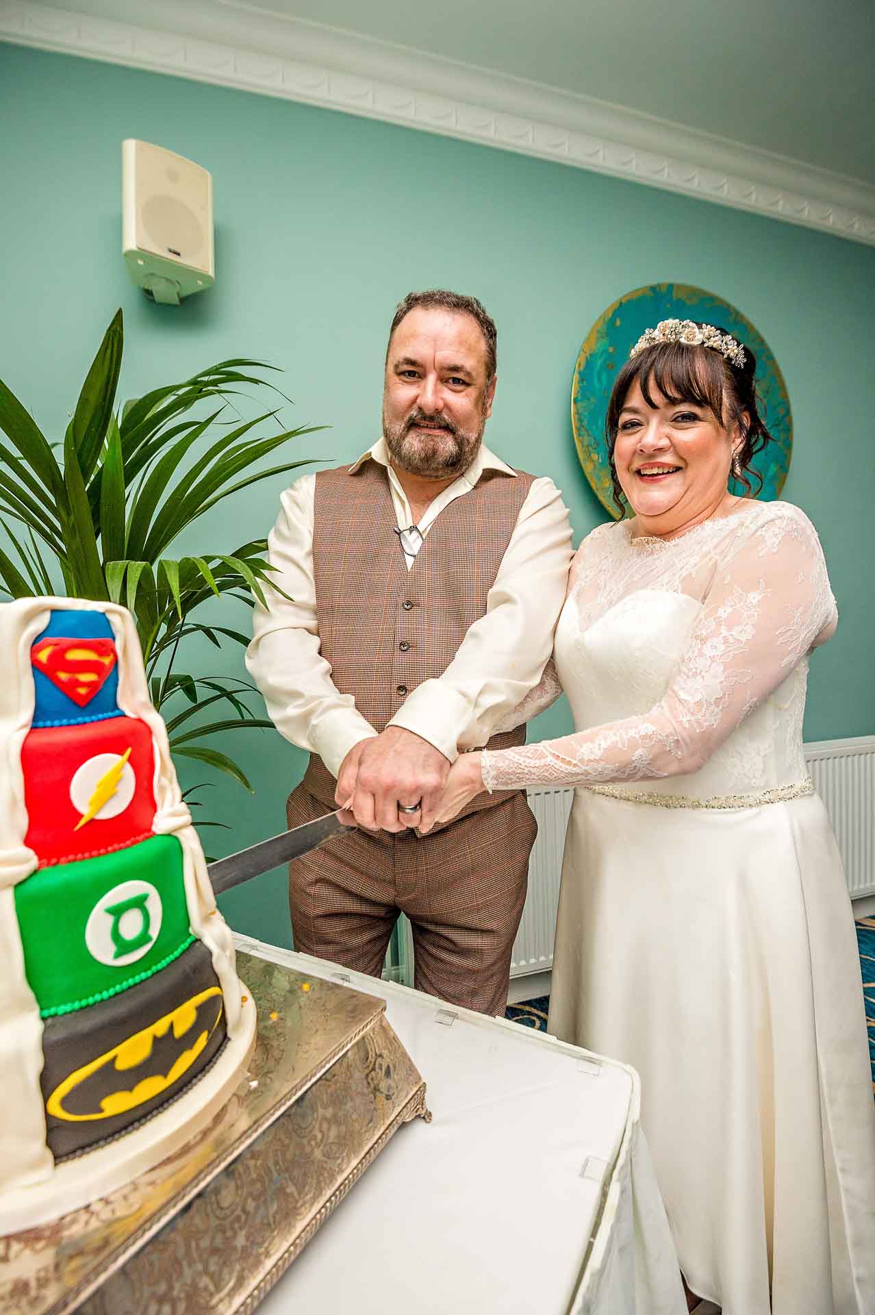 Bride and Groom Cutting Superhero Cake at Wedding