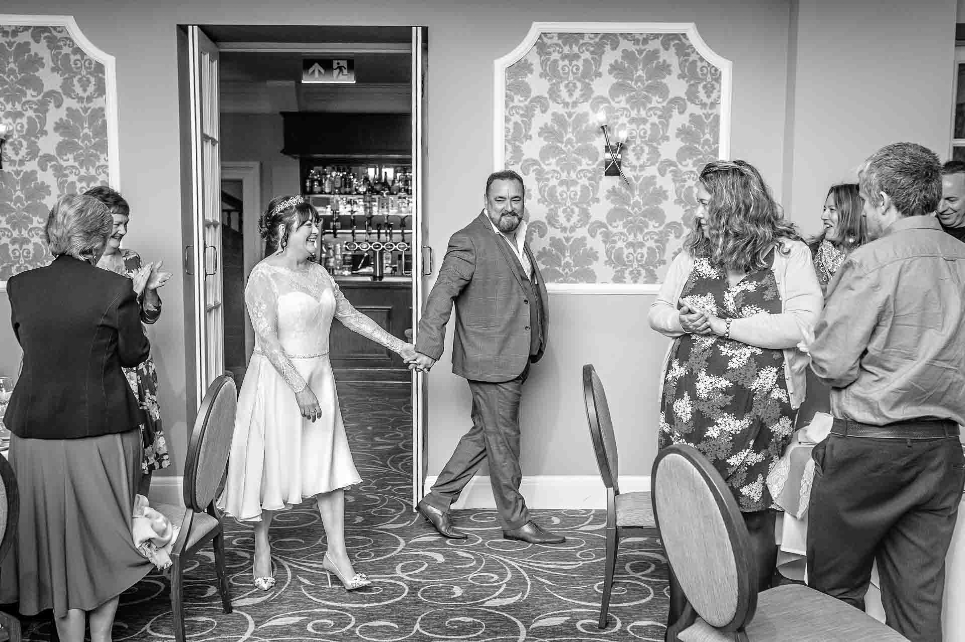 Bride and Groom Holding Hands as the Enter for Dinner - Manor Parc Hotel Wedding Photography