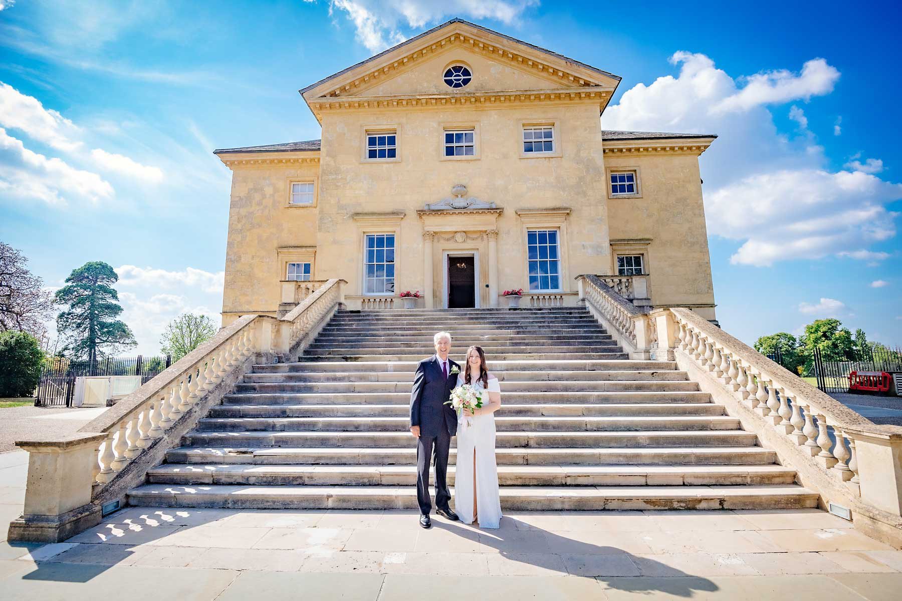 Bride poses with her father in front of Danson House in Kent before her wedding ceremony
