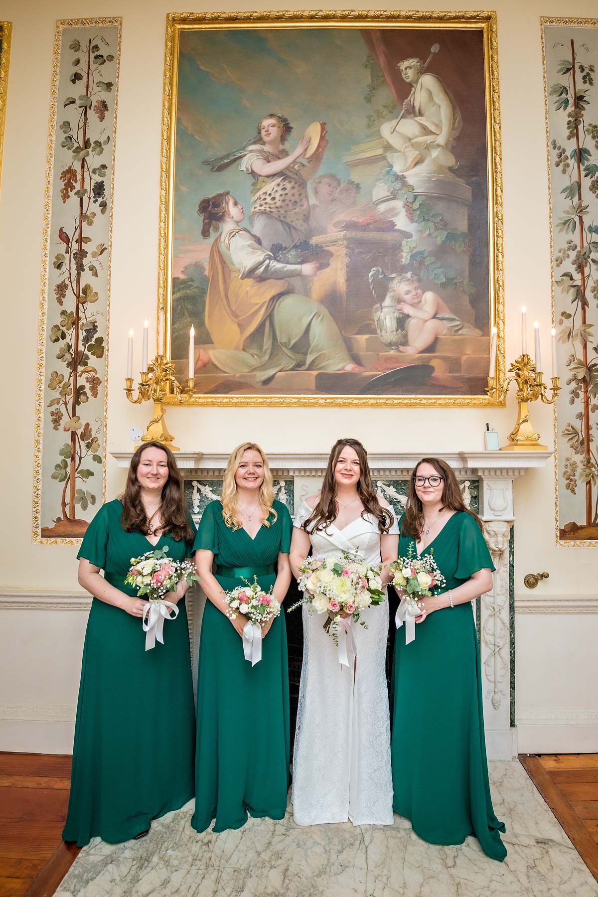 Bride posing with her 3 bridesmaids dressed in dark green dresses - taken in the Dining Room at Danson House