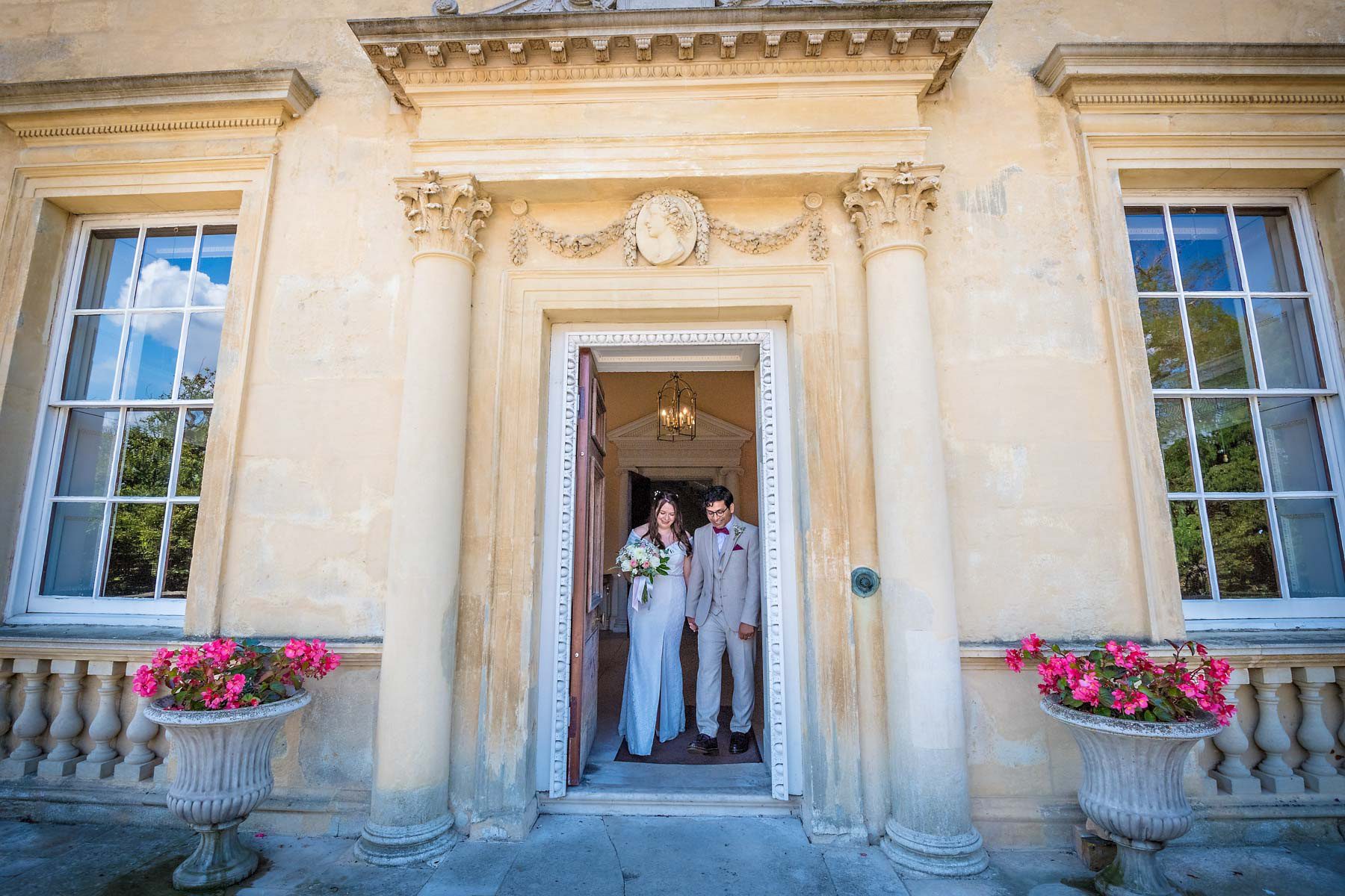 A wedded couple leave the entrance of Danson House after their ceremony
