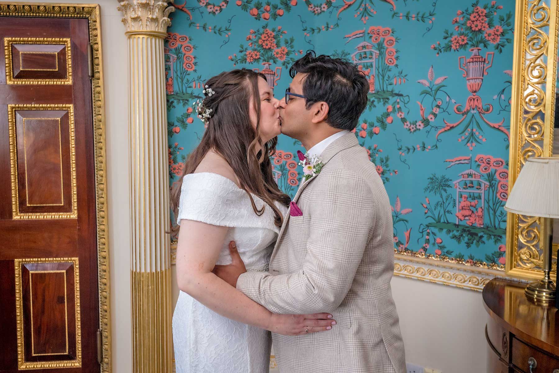 The newlyweds share their first kiss at their wedding in the Danson House Salon