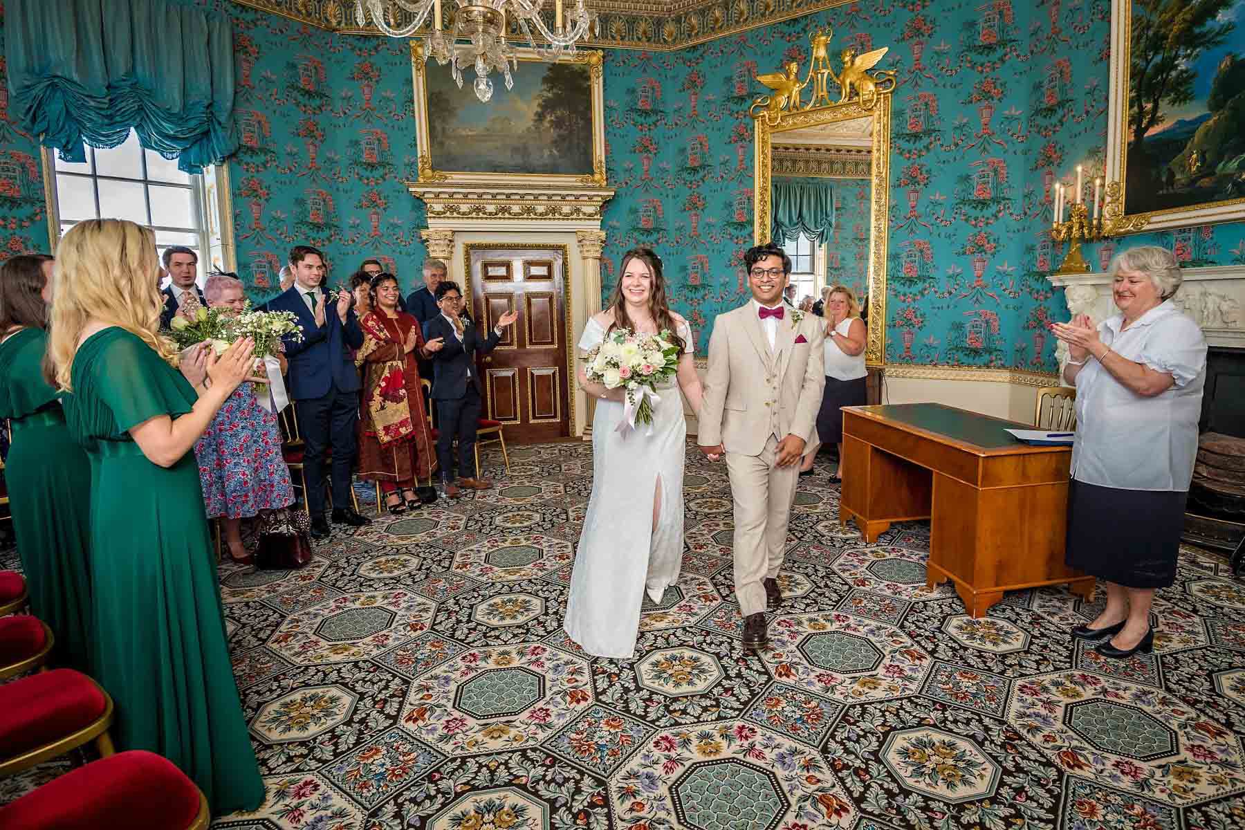 A newly wedded couple leave their wedding ceremony to a round of applause from their guests at registrars at Bexley Register Office