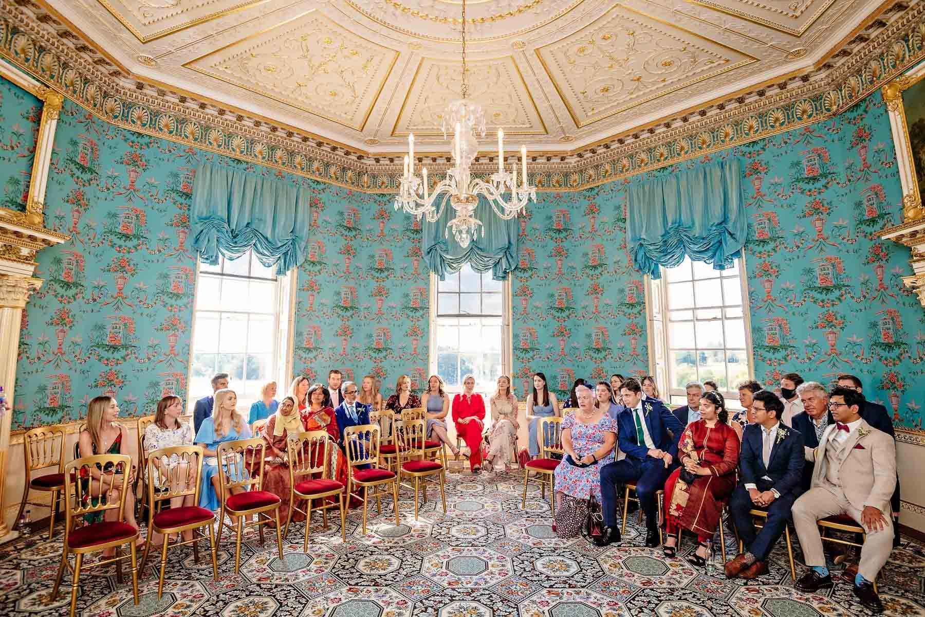 Guests and groom waiting in Danson House's Salon before the wedding ceremony