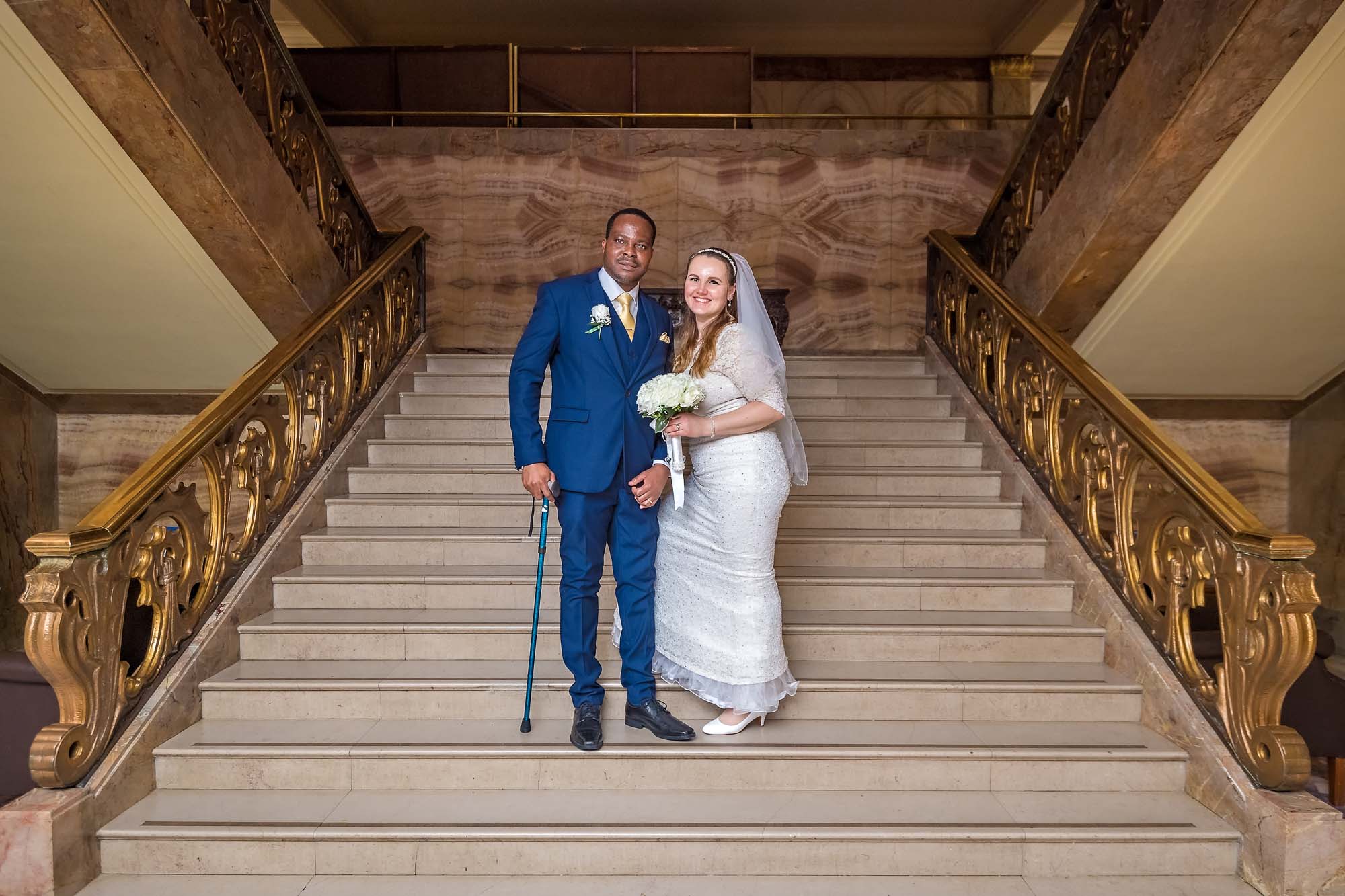 A just married couple pose on the marbled staircase of Wandsworth Town Hall