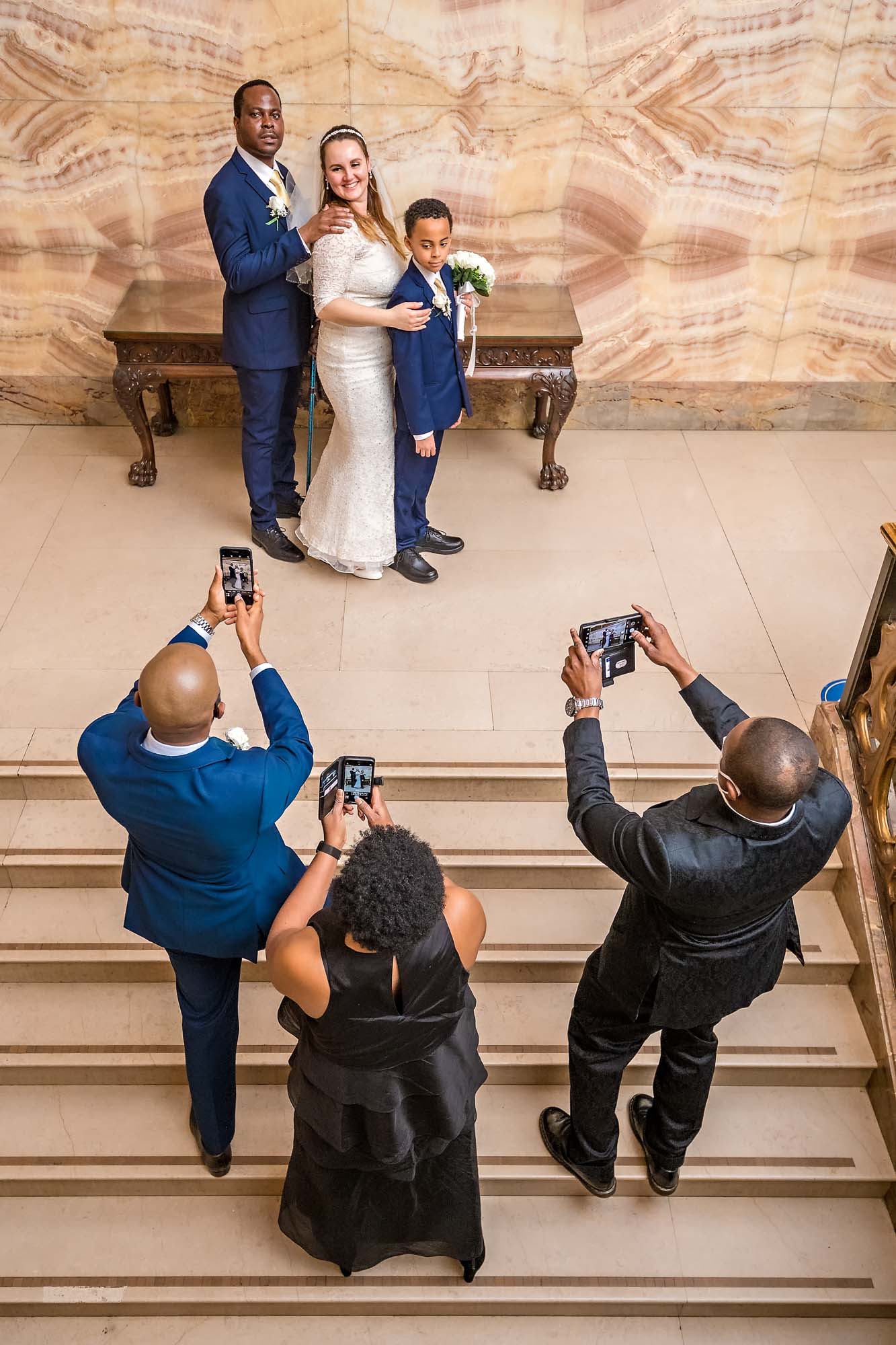 Capturing some guests taking posed photos of the couple on staircase