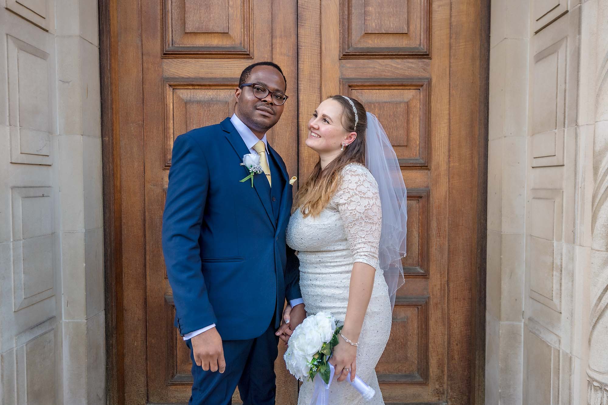 Bride and groom pose outside the doors of Wandsworth Register Office