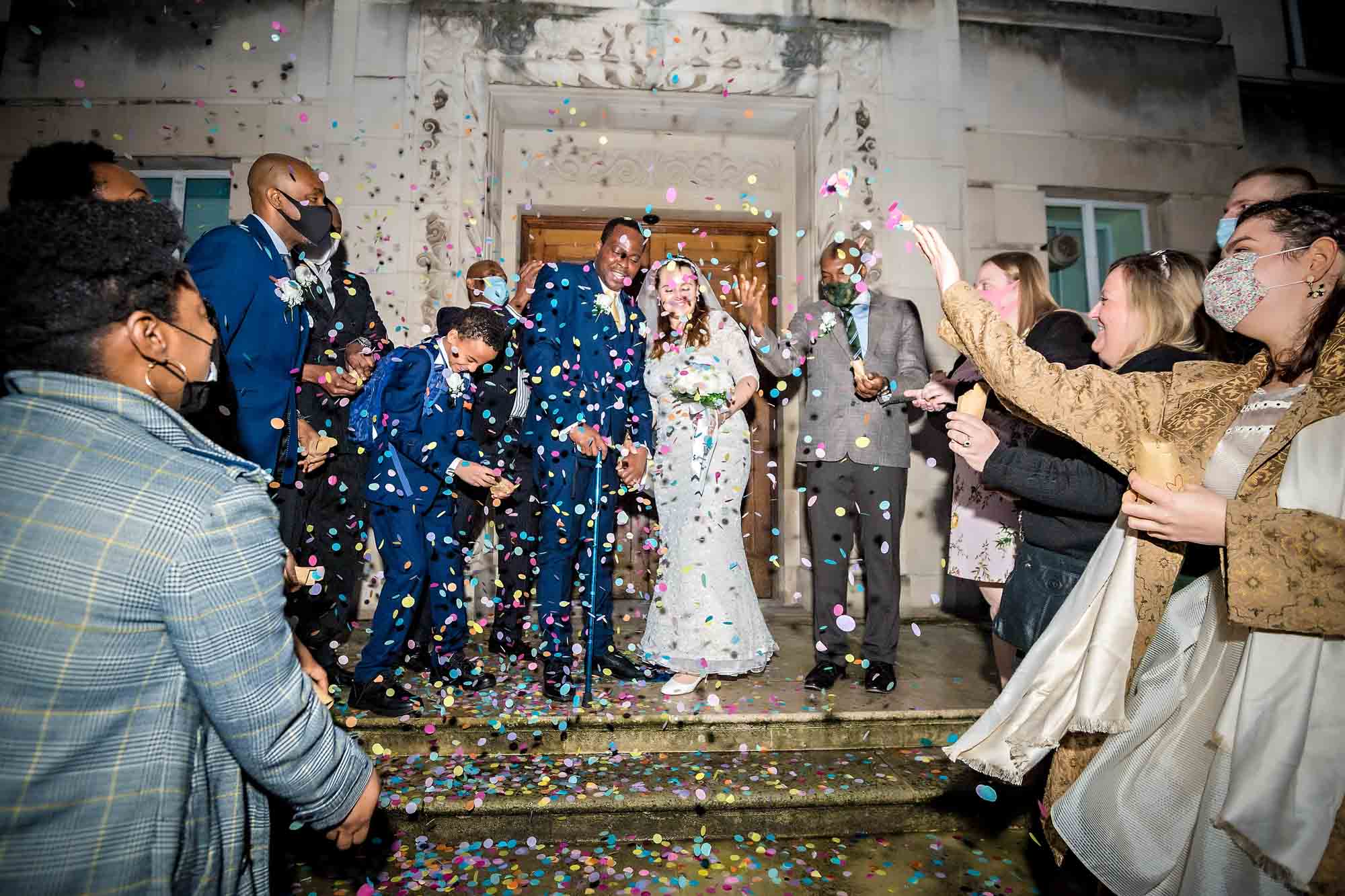 A flashlit confetti photo as the couple leave Wandsworth Town Hall in the dark
