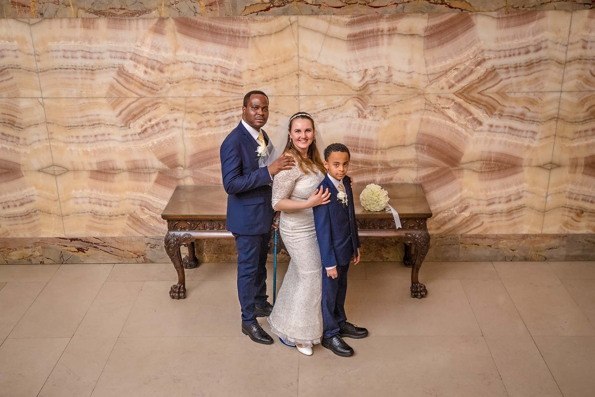 The couple pose with their son in the Marble Hall of Wandsworth Town Hall