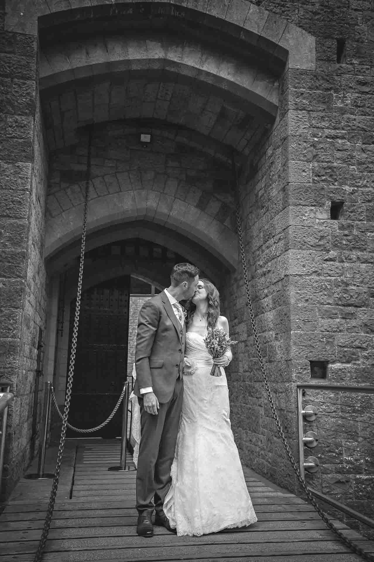 Couple kiss in entrance of Castell Coch in black and white