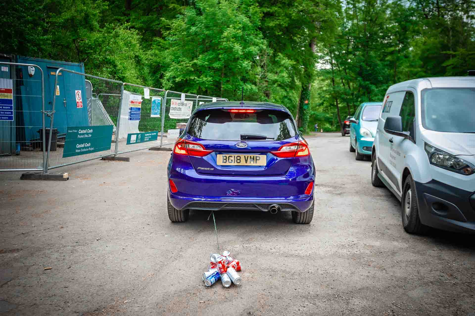 Wedding Cans Trailing Behind Blue Ford Fiesta