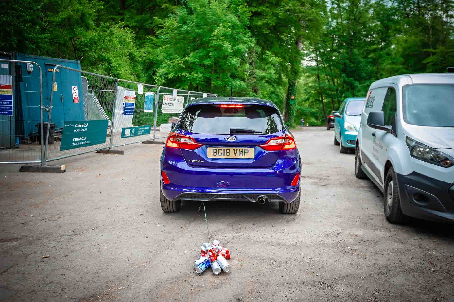 Wedding Cans Trailing Behind Blue Ford Fiesta