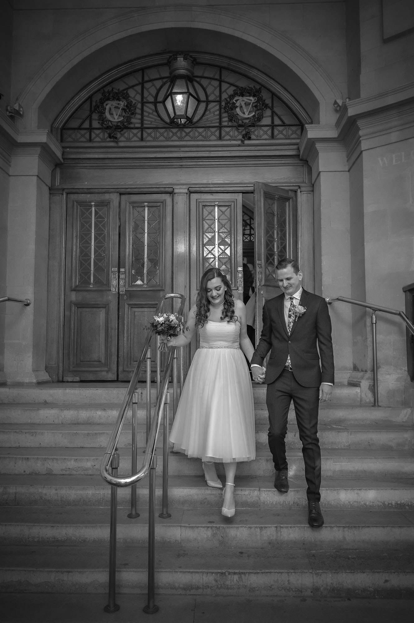 The newly-weds descend the City Hall steps after their wedding in Cardiff