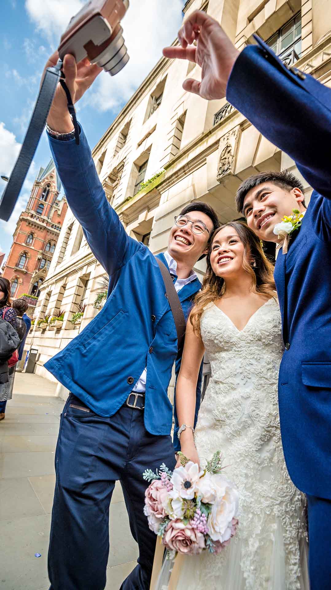Selfie of couple with male guest taken at London wedding